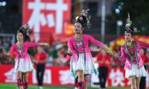 中国サッカーの試合で民族衣装で踊る女性